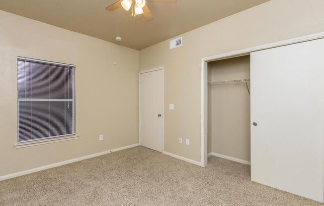 Bedroom with carpeted floors, walk-in closet, and ceiling fanÂ 