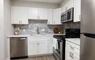 A kitchen with white cabinets at Dunwoody Glen, Georgia