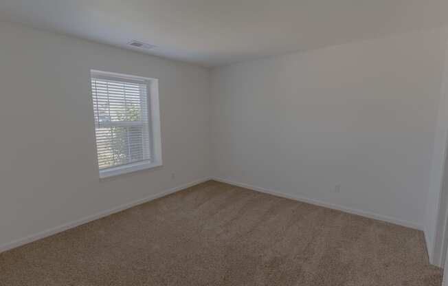 an empty room with carpet and a window