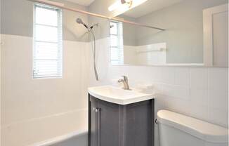 White tile bathroom in select units - Helios Apartments Miami Beach