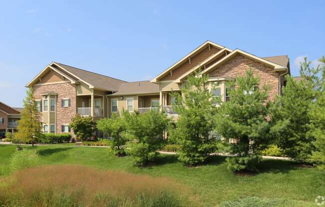 a large brick house with trees in front of it at Sovereign at Overland Park, Overland Park Kansas  