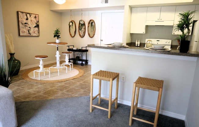 a kitchen and living room with a bar and stools