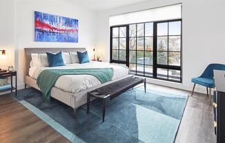 Light filled bedroom with floor to ceiling windows and modern furnishings