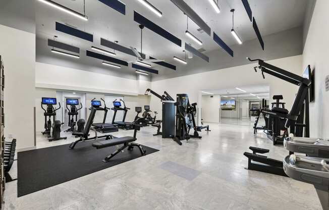 a spacious fitness room with treadmills and other exercise equipment