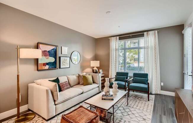 A living room with a white couch, a coffee table, and a painting on the wall.