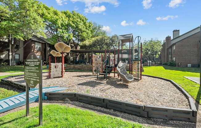 A playground with a slide, swings, and a sign.