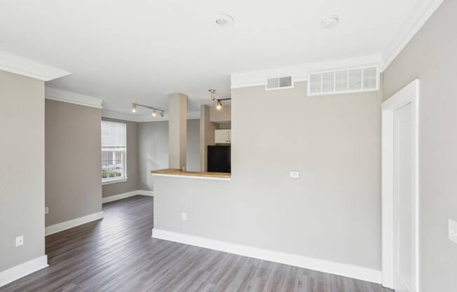 the living room and kitchen in a new home with wood floors and white walls