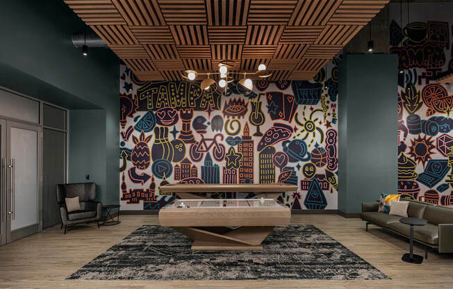A living room with a large mural on the wall and a wooden ceiling.