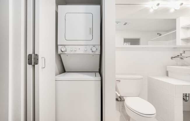 a bathroom with a toilet and a washer and dryer