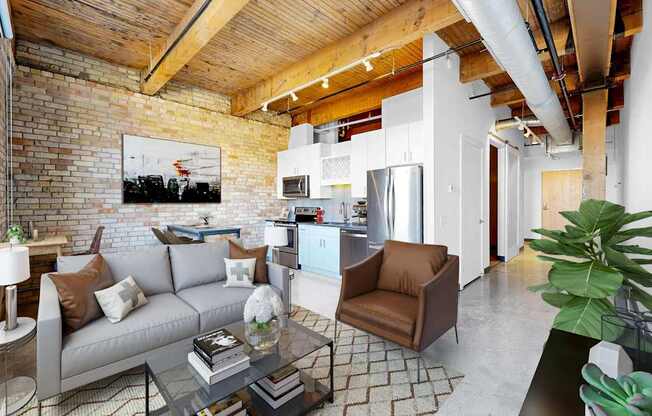 A living room with a grey couch and a glass coffee table.