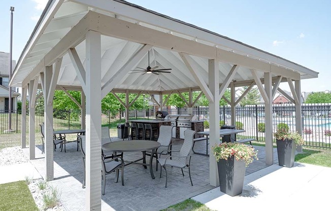 a covered patio with tables and chairs