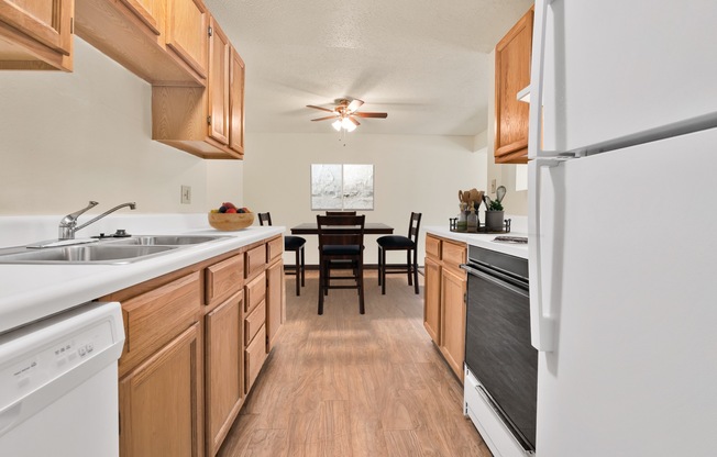A kitchen with wooden cabinets and a white fridge.