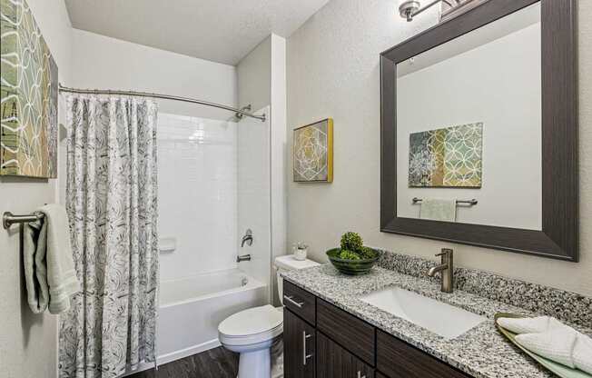 A bathroom with a toilet, sink, and shower.