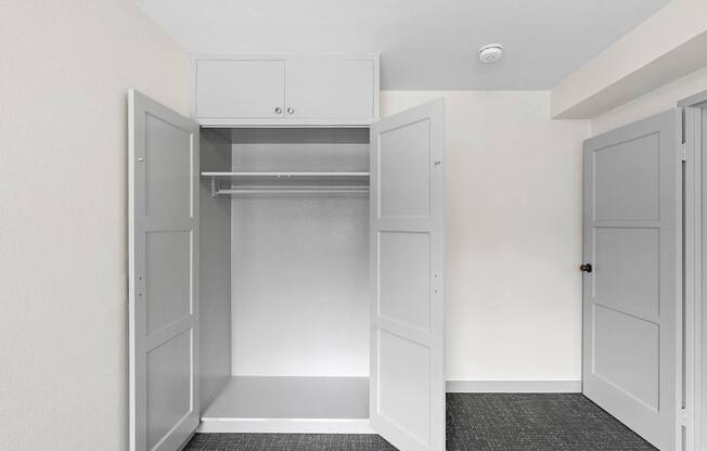 an empty closet in a home with white walls and white doors