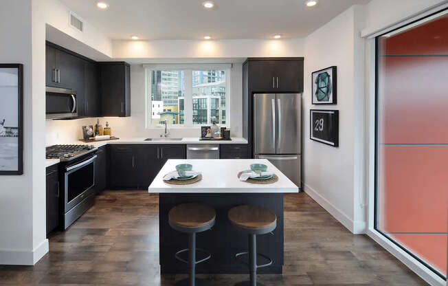 A modern kitchen with a large island and stools.