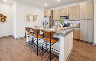 a kitchen with a island with four stools in front of it  at Palm Grove, Ellenton, FL, 34222