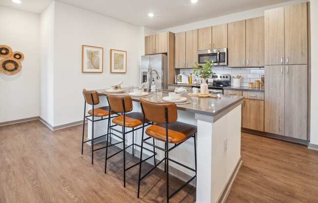 a kitchen with a island with four stools in front of it  at Palm Grove, Ellenton, FL, 34222