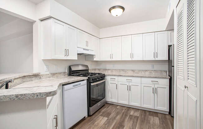 A kitchen with white cabinets and a breakfast bar at West Hampton Park Apartments in Elkhorn, NE 68022