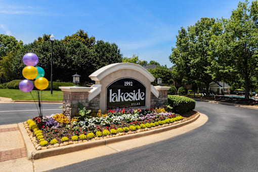 the sign at the entrance to the lakeside estates subdivision with flowers and balloons