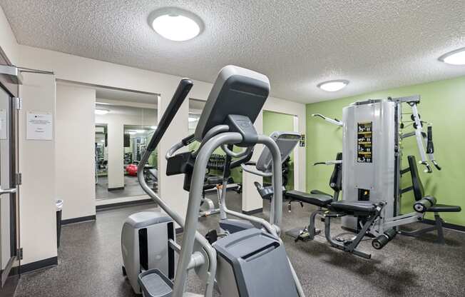 a gym with cardio equipment and weights at the enclave at university campuses