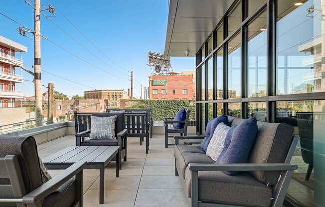 a balcony with couches and chairs and a baseball field in the background