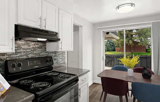 A modern kitchen with a black stove top oven and white cabinets.