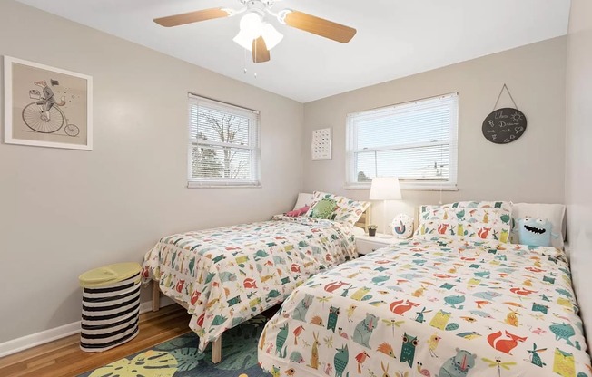 a bedroom with two beds and a ceiling fan
