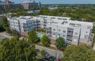 a view of a building from above with a pool and trees