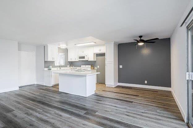 A spacious kitchen with white cabinets and a large island.