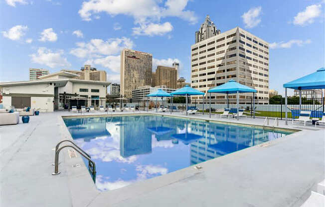 A large swimming pool with a city skyline in the background.