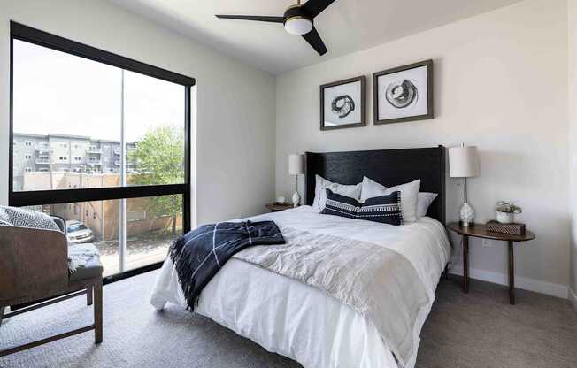 A bedroom with a large bed and a ceiling fan.