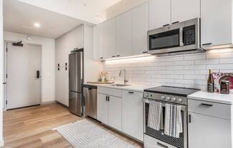 a kitchen with white cabinets and stainless steel appliances and a microwave at The Commonwealth Building, Pittsburgh, 15222