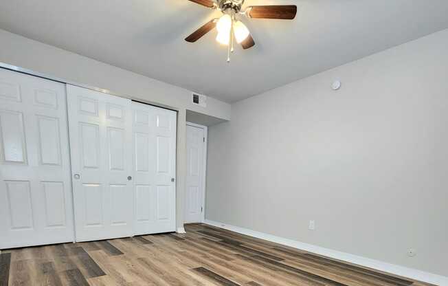 a living room with wood flooring and a ceiling fan