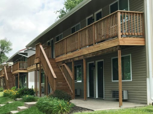 a building with a porch and a wooden deck staircase