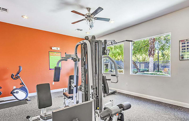 the gym has plenty of exercise equipment and a large window