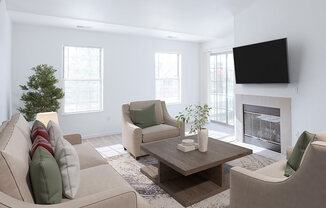 A living room with a couch, chairs, a coffee table, and a fireplace.