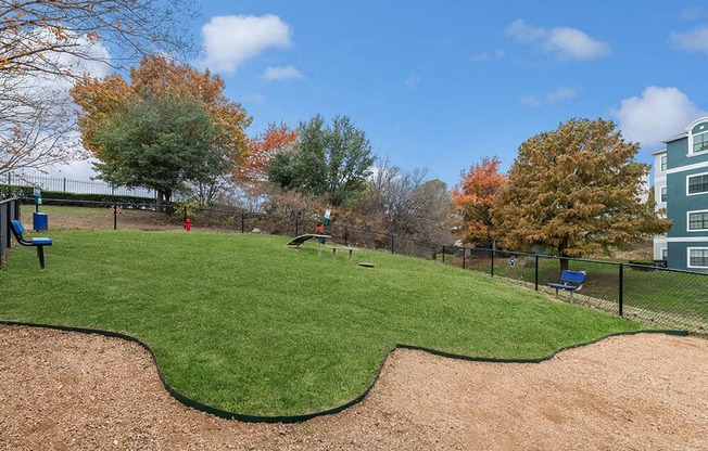 Community Dog Park with Agility Equipment at Bridges at Oakbend Apartments in Lewisville, TX.