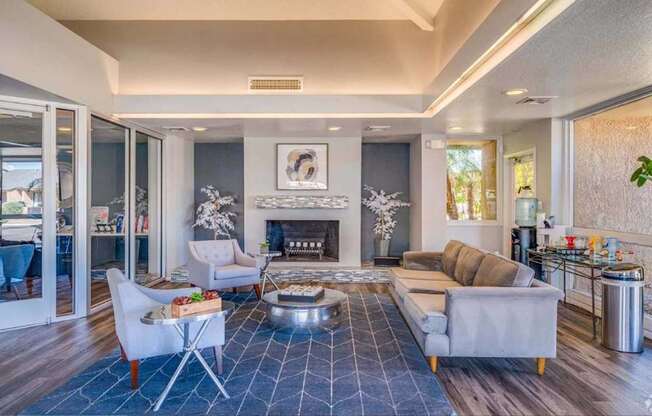 A modern living room with a fireplace and a blue rug.