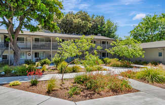 A sunny day at a residential complex with a well-maintained garden in the foreground.