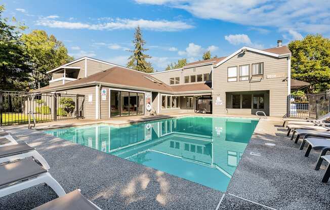 A large swimming pool in front of a building with a sunny day.