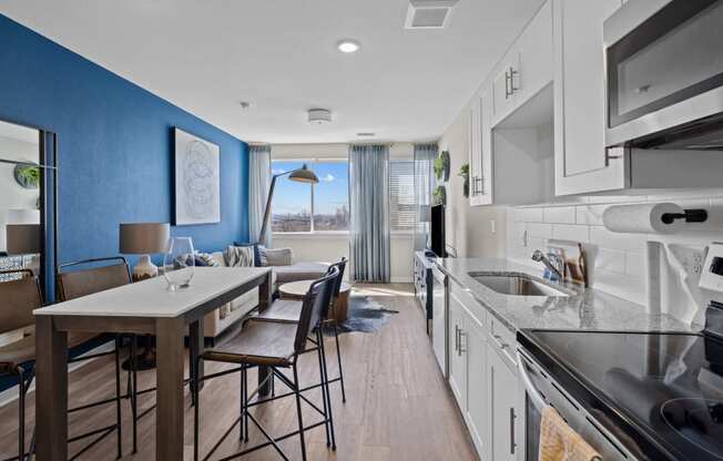 a kitchen and living room with blue walls and white cabinets at Alton Jefferson Park, Denver, 80211