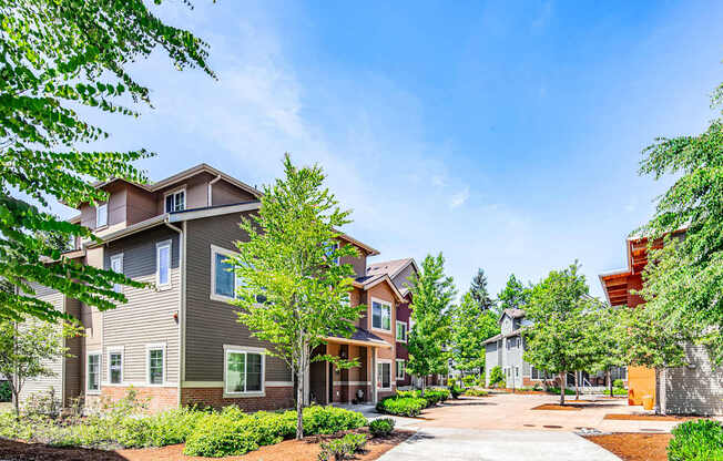 A row of houses with trees in front of them.