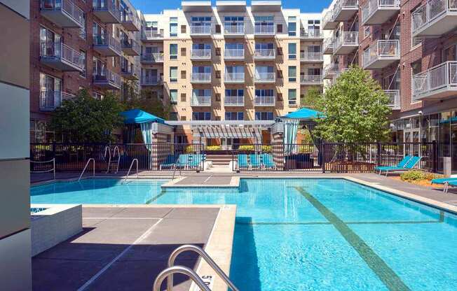 A large swimming pool in front of apartment buildings.