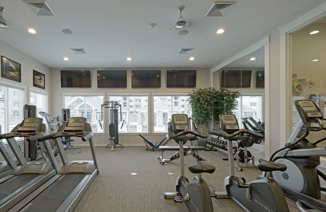 Fitness center with 2 treadmills, 2 stationary bikes, 1 elliptical, 4 flat screen televisions, free weights, and 4 weight machines