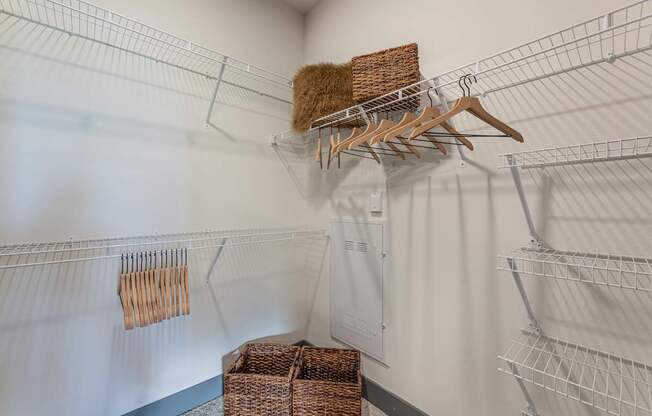 A white closet with a hanger and a basket.
