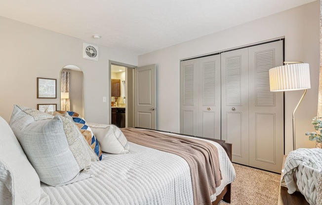 A bedroom with a large bed and a mirror on the wall.