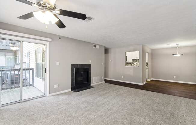 Unfurnished living room with a fireplace and a ceiling fan at Oakley Run apartments in Smyrna, GA