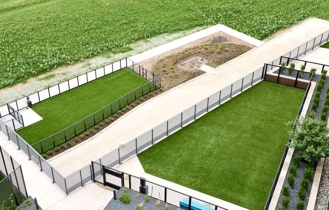 A black fence surrounds a green lawn.