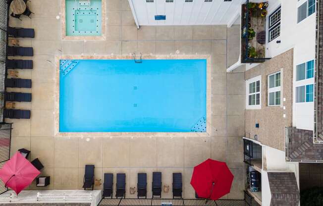 an overhead view of a pool and umbrellas on the side of a building