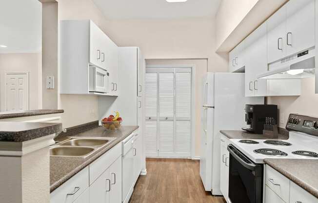 a kitchen with white cabinets and electric stove